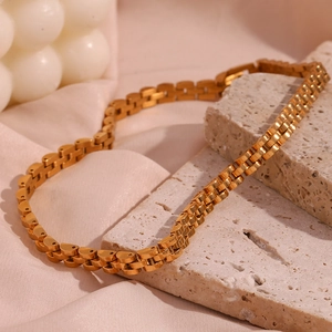 Detail of 18K gold-plated 6mm watch-strap chain choker on elegant pink silk background