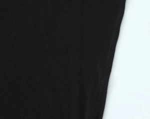 Close-up of high turtleneck seam showing the stitching on black cotton fabric