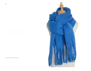 Detailed view of royal blue chunky knit mohair scarf with thick fringe tassels