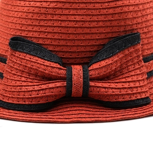 Chapeau de soleil en paille orange avec texture tissée et détail de nœud noir