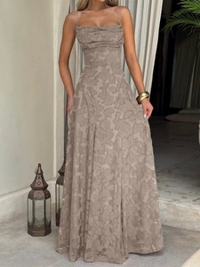 Robe longue évasée beige à motifs avec fines bretelles présentée sur une terrasse vintage