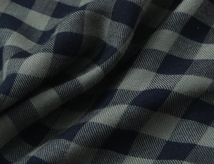 Macro shot of navy and grey plaid fabric showing fine twill texture and drape