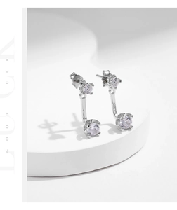 Macro view of S925 sterling silver studs with two-way zircon setting on white pedestal