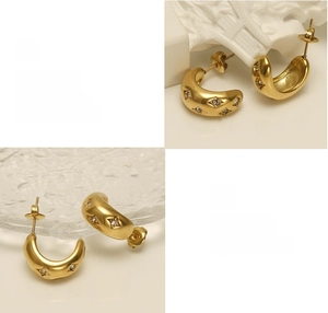 Detailed view of gold C-shaped earrings featuring starburst set zirconia accents