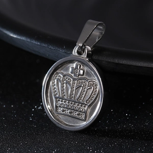 Macro detail of a silver stainless steel dog tag pendant featuring a 3D embossed crown
