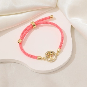 Dettaglio del bracciale intrecciato rosa con ciondolo albero della vita dorato regolabile