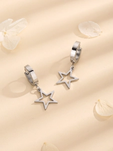 Polished silver stainless steel hollow star pendant earrings on beige background