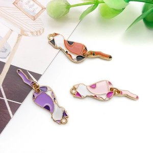 Detailed close-up of three colorful enamel cat charms in orange, purple and pink