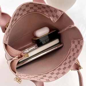Pink checkered crossbody bag with internal storage showing phone and earphones