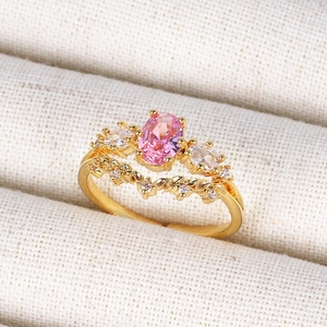 Detail of 18K gold ring with oval pink gemstone and sparkling clear zircons