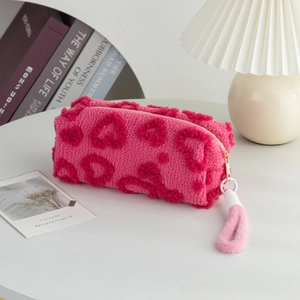 Detailed view of pink plush heart stationery bag on a cozy desk with aesthetic decor