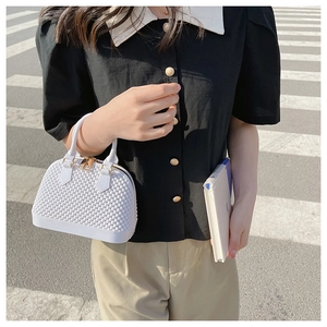 White PVC shell bag with bubble texture shown in a lifestyle street setting