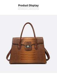 Detail of a brown crocodile pattern tote bag featuring a square metal twist lock closure
