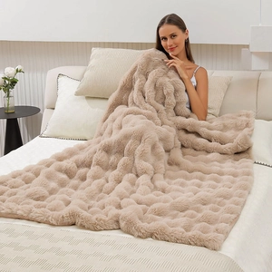 Detail showing the thick rippled texture and soft beige faux rabbit fur of the warm blanket
