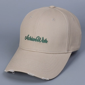 Detail of khaki cotton baseball cap with green embroidered text and distressed brim finish