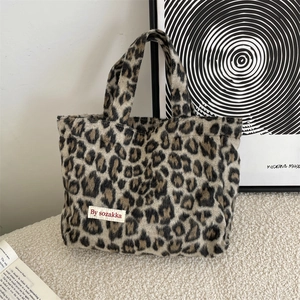 Detailed view of the soft leopard print tote bag fabric with a stitched brand label