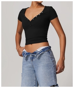 Close-up of black slim-fit crop top with V-neckline and decorative buttons