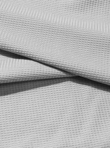 Macro primo piano della trama del tessuto a nido d'ape grigio chiaro della polo da uomo
