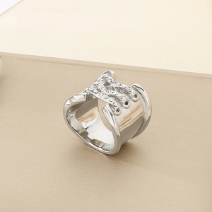Macro shot of wide silver ring with knot design and sparkling rhinestone embellishments
