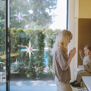 Rainbow holographic star window stickers showing vibrant prism effects in a cozy home scene