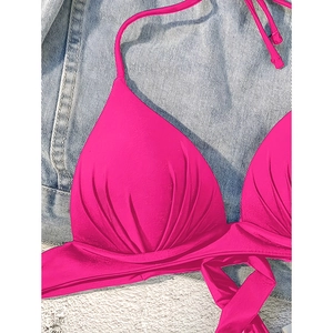 Detailed view of fuchsia halter bikini top with ruched texture and wrap-around ties