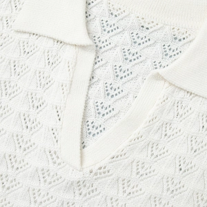 Close-up of white pointelle knit polo collar and detailed geometric hollow-out pattern