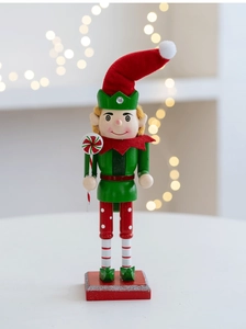 Macro detail of wooden Christmas nutcracker soldier holding a lollipop on gold bokeh background