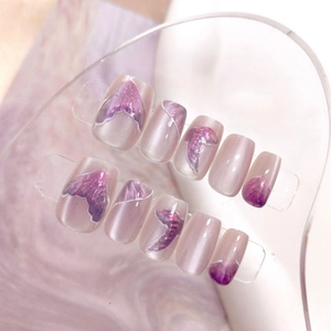 Detail of purple mermaid cat-eye press-on nails with glitter scales on display board