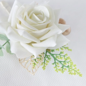 Elegant white artificial rose boutonniere with golden metal leaf for wedding attire