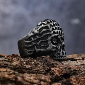 Makroaufnahme von Vintage-Totenkopfring auf Baumrinde zeigt gotische Punk-Details