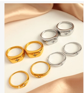 Collection of gold and silver North Star rings on elegant champagne silk fabric