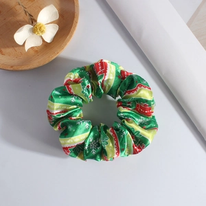 Detail of Christmas plush scrunchie with festive red and green snowflake patterns