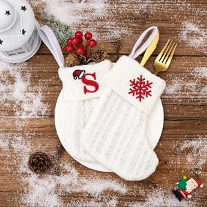 Close-up of white knitted Christmas stockings with red letter S and snowflake embroidery