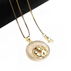 Macro detail of gold plated MOM shell pendant with zircon inlay and mother-child design