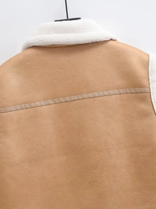 Detailed close-up of khaki faux leather shoulder stitching and white shearling lining