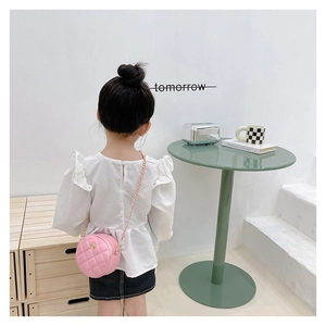 Rear view of a child wearing a pink quilted round bag with a gold flower buckle