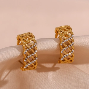 Détail de boucles d'oreilles en maille dorée avec zircons sur soie champagne