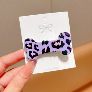 Macro shot of purple leopard print bone hair clip with black and pink pattern