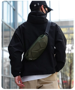 Model wearing army green hard shell chest bag for outdoor commuting in urban setting