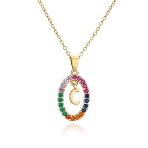 Macro shot of gold oval pendant featuring colorful zircon stones and letter C detail