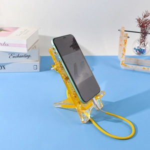 Detail view of transparent gold foil resin phone stand with a convenient charging port hole