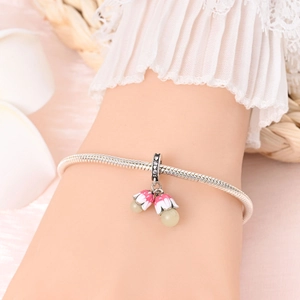 Close-up of a silver charm bracelet with pink enamel lily of the valley and rhinestones