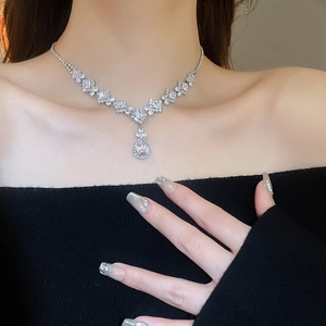 Close-up of elegant silver zircon waterdrop pendant necklace on a female model