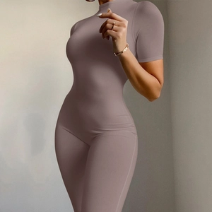 Close-up of mauve short sleeve yoga jumpsuit featuring a slim fit and front zipper detail