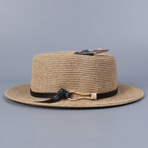 Détail du tissage de paille fine sur chapeau de soleil plat avec lanière en cuir