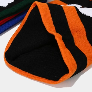 Close-up of orange and black striped knit hat showing rib weave texture and thick material
