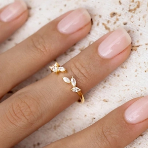 Close-up of a gold leaf open ring with marquise-cut zircon stones on a woman's finger