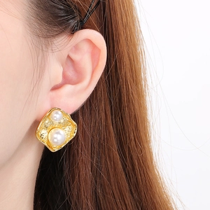 Gros plan détaillé de boucles d'oreilles fleur de lave en acier doré 18k avec perles