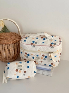 Close-up of quilted corduroy cosmetic bags with vintage floral patterns and fabric label