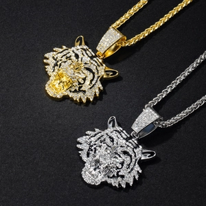 Detail of gold and silver tiger head pendants with rhinestones on Cuban link chains